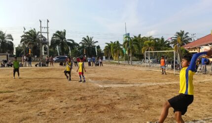 Seorang pemain cilik melakukan lemparan ke dalam (throw-in) saat laga hari ke-11 Turnamen Sepak Bola tingkat SD #BMT CUP 2026 di Lapangan Desa Karang Tengah, Kecamatan Buay Madang Timur, Kabupaten OKU Timur.