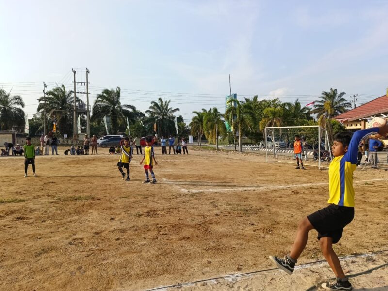 Seorang pemain cilik melakukan lemparan ke dalam (throw-in) saat laga hari ke-11 Turnamen Sepak Bola tingkat SD #BMT CUP 2026 di Lapangan Desa Karang Tengah, Kecamatan Buay Madang Timur, Kabupaten OKU Timur. 