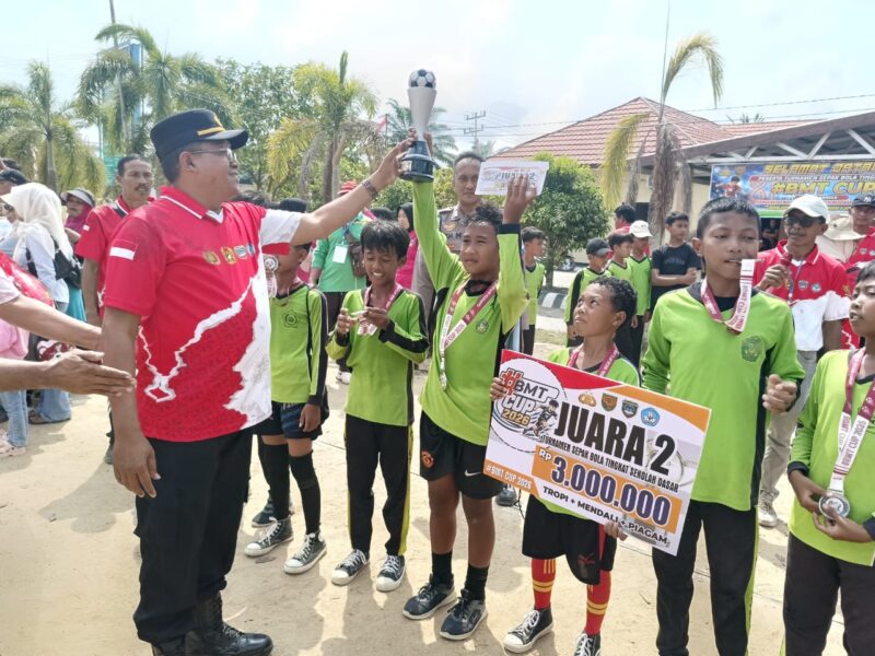 Kapolsek Buay Madang Timur Iptu Swisspo, menyerahkan trofi dan hadiah uang pembinaan secara simbolis kepada tim sepak bola MI Sumber Mulyo yang berhasil meraih posisi Juara 2 dalam Turnamen Sepak Bola Tingkat Sekolah Dasar #BMT Cup Tahun 2026 di Mako Polsek Buay Madang Timur, Kabupaten OKU Timur. 