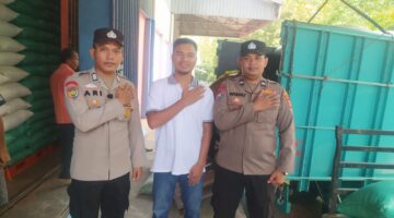 Personel Polsek Buay Madang Timur, Bripka Ari Wicaksono, dan Aipda Wisnu, melakukan salam komando bersama perwakilan petani saat mengawal penyaluran hasil panen di Gudang Bulog Terukis, Kecamatan Martapura, Kabupaten OKU Timur, Sumatera Selatan. 