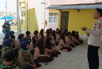 Kanit Binmas Polsek Buay Madang Timur Bripka Ari Wicaksono, dan Bhabinkamtibmas Brigadir Tedy Heryadi, memberikan pembekalan materi kepada puluhan anggota Pramuka di kompleks SD Negeri Eling-Eling, Desa Tanjung Sari, OKU Timur. 