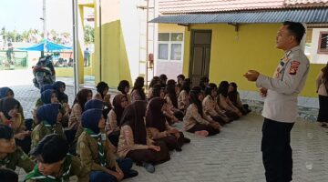 Kanit Binmas Polsek Buay Madang Timur Bripka Ari Wicaksono, dan Bhabinkamtibmas Brigadir Tedy Heryadi, memberikan pembekalan materi kepada puluhan anggota Pramuka di kompleks SD Negeri Eling-Eling, Desa Tanjung Sari, OKU Timur. 