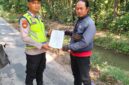 Personel Polsek Buay Madang Timur, Bripka Iswanto menyerahkan lembaran kertas Maklumat Karhutla kepada seorang warga saat menggelar kegiatan sambang di Desa Tanjung Sari, Kecamatan Buay Madang Timur, Kabupaten OKU Timur. 