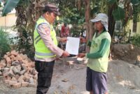 Personil Polsek Buay Madang Timur menyerahkan lembaran Maklumat Kapolda Sumsel mengenai larangan membakar hutan dan lahan kepada salah seorang warga di Desa Sumber Asri, OKU Timur. 