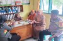 Anggota Bhabinkamtibmas Polsek Buay Madang Timur, Aipda Sahrul, berdialog dengan staf kesehatan dan warga di Puskesmas Pembantu Tanjung Mas, Desa Tanjung Mulya, Kecamatan Buay Madang Timur, Kabupaten OKU Timur. 
