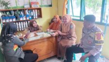 Anggota Bhabinkamtibmas Polsek Buay Madang Timur, Aipda Sahrul, berdialog dengan staf kesehatan dan warga di Puskesmas Pembantu Tanjung Mas, Desa Tanjung Mulya, Kecamatan Buay Madang Timur, Kabupaten OKU Timur. 