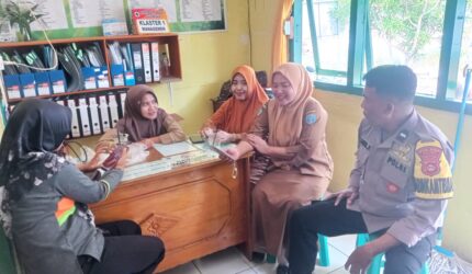 Anggota Bhabinkamtibmas Polsek Buay Madang Timur, Aipda Sahrul, berdialog dengan staf kesehatan dan warga di Puskesmas Pembantu Tanjung Mas, Desa Tanjung Mulya, Kecamatan Buay Madang Timur, Kabupaten OKU Timur.