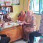 Anggota Bhabinkamtibmas Polsek Buay Madang Timur, Aipda Sahrul, berdialog dengan staf kesehatan dan warga di Puskesmas Pembantu Tanjung Mas, Desa Tanjung Mulya, Kecamatan Buay Madang Timur, Kabupaten OKU Timur. 