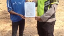 Bhabinkamtibmas Polsek Buay Madang Timur Aipda Wisnu Saputra menunjukkan dan menyerahkan lembaran Maklumat Kapolda Sumsel tentang larangan membakar hutan dan lahan kepada seorang warga saat giat mitigasi Karhutla di wilayah Kecamatan Buay Madang Timur, OKU Timur.