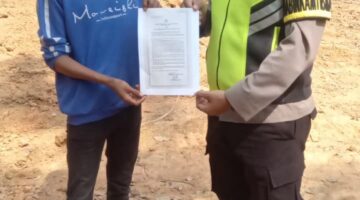 Bhabinkamtibmas Polsek Buay Madang Timur Aipda Wisnu Saputra menunjukkan dan menyerahkan lembaran Maklumat Kapolda Sumsel tentang larangan membakar hutan dan lahan kepada seorang warga saat giat mitigasi Karhutla di wilayah Kecamatan Buay Madang Timur, OKU Timur.