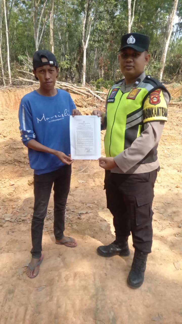 Bhabinkamtibmas Polsek Buay Madang Timur Aipda Wisnu Saputra menunjukkan dan menyerahkan lembaran Maklumat Kapolda Sumsel tentang larangan membakar hutan dan lahan kepada seorang warga saat giat mitigasi Karhutla di wilayah Kecamatan Buay Madang Timur, OKU Timur. 