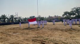 Anggota Paskibraka dari SMA Muhammadiyah membentangkan bendera Merah Putih dalam Upacara Peringatan HUT ke-81 Kemerdekaan Republik Indonesia di Lapangan Kantor Kecamatan Buay Madang Timur, OKU Timur, Sumatera Selatan.