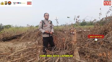 Bhabinkamtibmas Polsek Buay Madang Timur Brigadir Tedy Heryadi, memberikan imbauan pelarangan karhutla di samping spanduk peringatan saat menggelar patroli mitigasi kebakaran lahan di Desa Pengandonan, Kecamatan Buay Madang Timur, OKU Timur, Sumatera Selatan.