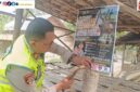 Kapolsek Buay Madang Timur Iptu Swisspo, memasang spanduk imbauan larangan membakar sampah dan daun kering di salah satu desa di Kecamatan Buay Madang Timur, OKU Timur.