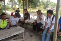 Personel Polsek Buay Madang Timur, Aipda Sahrul Munir, berdialog dan memberikan imbauan kamtibmas kepada warga serta pelajar di area Balai Desa Sumber Harjo, Kecamatan Buay Madang Timur, OKU Timur.