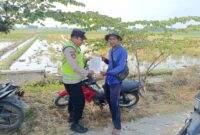 Personel Polsek Buay Madang Timur menyerahkan lembaran Maklumat Kapolda Sumsel mengenai larangan membakar lahan kepada seorang petani di area persawahan Desa Pengandonan, Kecamatan Buay Madang Timur, OKU Timur.