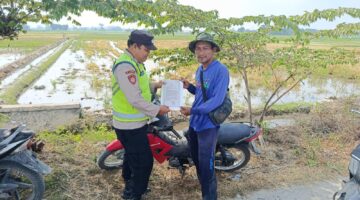 Personel Polsek Buay Madang Timur menyerahkan lembaran Maklumat Kapolda Sumsel mengenai larangan membakar lahan kepada seorang petani di area persawahan Desa Pengandonan, Kecamatan Buay Madang Timur, OKU Timur.