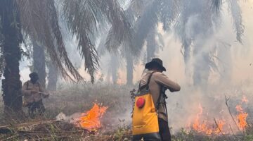 Personel Polda Sumsel padamkan api. Foto: dokumen polisi.