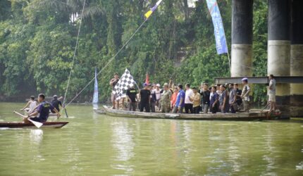 Bupati OKU Timur Lanosin, bersama tokoh masyarakat membaur di atas rakit saat melepas peserta Lomba Bidar Tradisional di Desa Tanjung Kemala, OKU Timur.