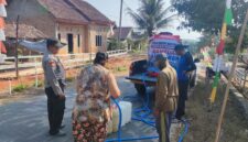 Kapolsek Buay Madang Timur Iptu Swisspo, memantau langsung pengisian air bersih ke jeriken milik seorang warga di Desa Teko Rejo, Kecamatan Buay Madang Timur, Kabupaten OKU Timur.