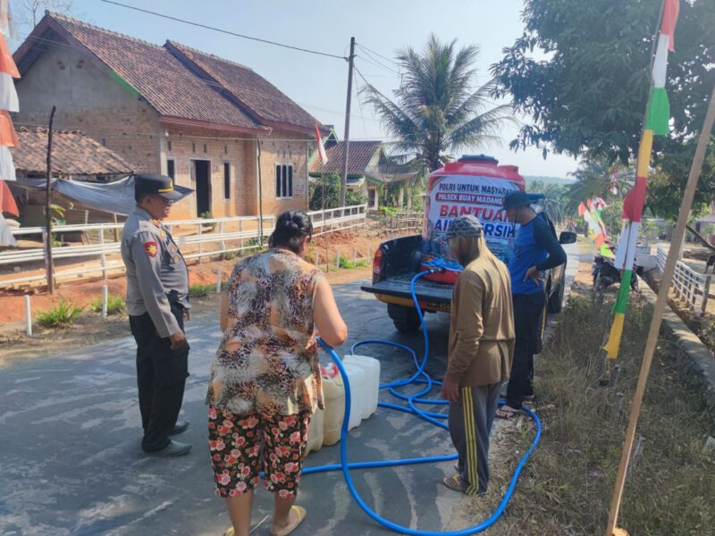 Kapolsek Buay Madang Timur Iptu Swisspo, memantau langsung pengisian air bersih ke jeriken milik seorang warga di Desa Teko Rejo, Kecamatan Buay Madang Timur, Kabupaten OKU Timur.
