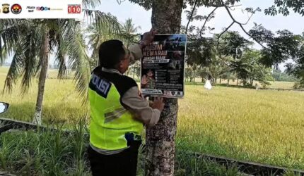 Kapolsek Buay Madang Timur Iptu Swisspo, memasang spanduk imbauan larangan membakar sampah dan daun kering di sebuah pohon di kawasan Desa Sumedang Sari, Kecamatan Buay Madang Timur, Kab. OKU Timur.