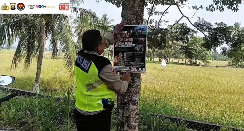 Kapolsek Buay Madang Timur Iptu Swisspo, memasang spanduk imbauan larangan membakar sampah dan daun kering di sebuah pohon di kawasan Desa Sumedang Sari, Kecamatan Buay Madang Timur, Kab. OKU Timur.