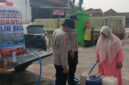 Warga Desa Teko Rejo mengantre untuk menerima pembagian air bersih gratis dari Polsek Buay Madang Timur di OKU Timur.