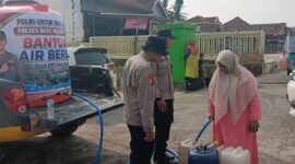Warga Desa Teko Rejo mengantre untuk menerima pembagian air bersih gratis dari Polsek Buay Madang Timur di OKU Timur.