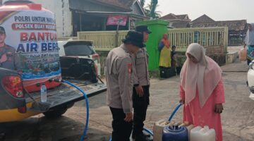Warga Desa Teko Rejo mengantre untuk menerima pembagian air bersih gratis dari Polsek Buay Madang Timur di OKU Timur.