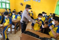 Kapolsek Buay Madang Timur IPTU Swisspo, membagikan masker gratis secara langsung kepada pelajar saat menggelar program Goes To School di SMK NU Desa Sumber Mulyo, Kecamatan Buay Madang Timur, Kabupaten OKU Timur.