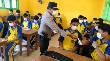 Kapolsek Buay Madang Timur IPTU Swisspo, membagikan masker gratis secara langsung kepada pelajar saat menggelar program Goes To School di SMK NU Desa Sumber Mulyo, Kecamatan Buay Madang Timur, Kabupaten OKU Timur.