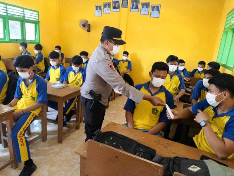 Kapolsek Buay Madang Timur IPTU Swisspo, membagikan masker gratis secara langsung kepada pelajar saat menggelar program Goes To School di SMK NU Desa Sumber Mulyo, Kecamatan Buay Madang Timur, Kabupaten OKU Timur.