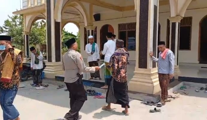 Kapolsek Buay Madang Timur Iptu Swisspo menyerahkan masker gratis secara langsung kepada jemaah di halaman Masjid At-Taubat, Desa Sumber Harjo, Kecamatan Buay Madang Timur, Kabupaten OKU Timur.