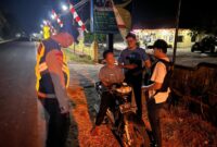 Personel Polsek Buay Madang Timur menghentikan dan memeriksa kelengkapan surat serta barang bawaan pengendara sepeda motor saat menggelar Patroli KRYD dan razia malam di Jalan Lintas Belitang - Gumawang, Desa Karang Tengah, Kecamatan Buay Madang Timur, Kabupaten OKU Timur, Sumatera Selatan.