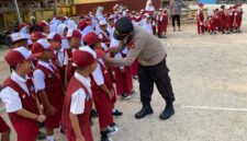 Kapolsek Buay Madang Timur Iptu Swisspo, memasangkan masker secara langsung kepada seorang siswa saat memimpin kegiatan Goes To School di SDN 2 Teko Rejo, Kabupaten OKU Timur.