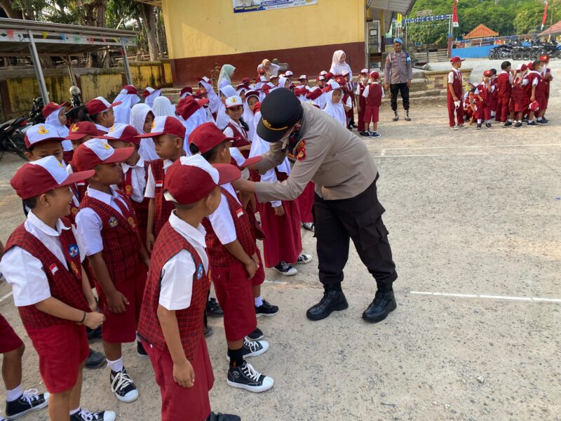 Kapolsek Buay Madang Timur Iptu Swisspo, memasangkan masker secara langsung kepada seorang siswa saat memimpin kegiatan Goes To School di SDN 2 Teko Rejo, Kabupaten OKU Timur.