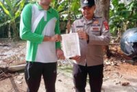 Anggota Polsek Buay Madang Timur, Aipda Wisnu Saputra menyerahkan lembaran Maklumat Kapolda Sumsel mengenai larangan membakar hutan dan lahan kepada salah seorang warga di Kecamatan Buay Madang Timur, Kabupaten OKU Timur, Sumatera Selatan. 