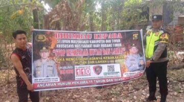 Personel Polsek Buay Madang Timur bersama warga membentangkan spanduk maklumat pelarangan membakar hutan dan lahan dalam kegiatan mitigasi Karhutla di Kecamatan Buay Madang Timur, Kabupaten OKU Timur.