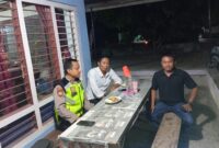 Anggota Polsek Buay Madang Timur Aipda Khoirul Alkhaf berdialog dengan warga saat melaksanakan kegiatan silaturahmi dan sambang malam di Desa Srikaton, Kecamatan Buay Madang Timur, Kabupaten OKU Timur.