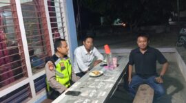 Anggota Polsek Buay Madang Timur Aipda Khoirul Alkhaf berdialog dengan warga saat melaksanakan kegiatan silaturahmi dan sambang malam di Desa Srikaton, Kecamatan Buay Madang Timur, Kabupaten OKU Timur.
