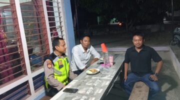 Anggota Polsek Buay Madang Timur Aipda Khoirul Alkhaf berdialog dengan warga saat melaksanakan kegiatan silaturahmi dan sambang malam di Desa Srikaton, Kecamatan Buay Madang Timur, Kabupaten OKU Timur.