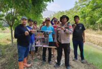 Kapolsek Buay Madang Timur Iptu Swisspo, bersama perangkat desa dan warga membentangkan pamflet imbauan larangan membakar lahan saat menggelar patroli mitigasi Karhutla di Desa Tambak Boyo, Kecamatan Buay Madang Timur, Kabupaten OKU Timur.