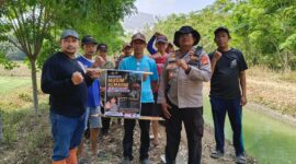 Kapolsek Buay Madang Timur Iptu Swisspo, bersama perangkat desa dan warga membentangkan pamflet imbauan larangan membakar lahan saat menggelar patroli mitigasi Karhutla di Desa Tambak Boyo, Kecamatan Buay Madang Timur, Kabupaten OKU Timur.