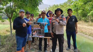 Kapolsek Buay Madang Timur Iptu Swisspo, bersama perangkat desa dan warga membentangkan pamflet imbauan larangan membakar lahan saat menggelar patroli mitigasi Karhutla di Desa Tambak Boyo, Kecamatan Buay Madang Timur, Kabupaten OKU Timur.
