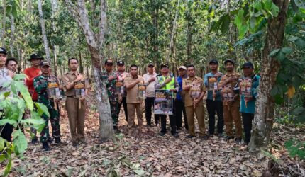 Kapolsek Buay Madang Timur (BMT) Iptu Swisspo, bersama Camat BMT Ramadhan Agusten, personel Koramil 403-05 Buay Madang, perangkat desa, serta Masyarakat Peduli Api berfoto bersama sambil membentangkan selebaran imbauan saat patroli gabungan mitigasi Karhutla di Desa Gumuk Rejo, OKU Timur.