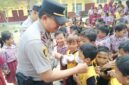 Kapolsek Buay Madang Timur (BMT) Iptu Swisspo, memasangkan masker secara langsung kepada salah seorang murid saat menggelar program Cooling System / Goes To School di SDN Rejodadi, Desa Rejodadi, Kecamatan Buay Madang Timur, OKU Timur.