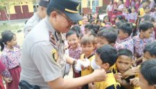 Kapolsek Buay Madang Timur (BMT) Iptu Swisspo, memasangkan masker secara langsung kepada salah seorang murid saat menggelar program Cooling System / Goes To School di SDN Rejodadi, Desa Rejodadi, Kecamatan Buay Madang Timur, OKU Timur.