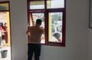Personil Polsek Buay Madang Timur (BMT) membersihkan kaca dan area jendela saat melaksanakan program Belida (Bersih Lingkungan dan Asri) di Rumah Dinas Polsek BMT, Kabupaten OKU Timur.
