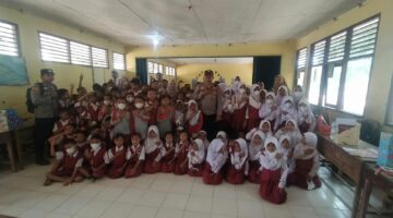 Kapolsek Buay Madang Timur, Iptu Swisspo, bersama personel Polsek, guru, dan ratusan siswa-siswi berfoto bersama dalam kegiatan Sambang, Cooling System, dan Pembagian Masker Gratis di SD N 1 Tekorejo, Desa Tekorejo, Kecamatan Buay Madang Timur, OKU Timur.